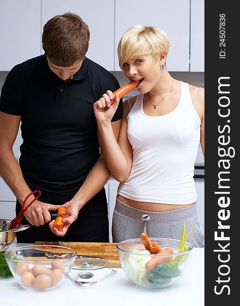 Playful young couple in their kitchen making dinner