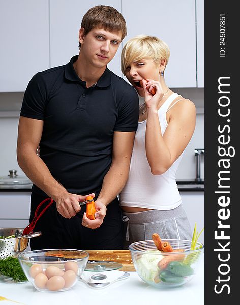 Playful young couple in their kitchen making dinner