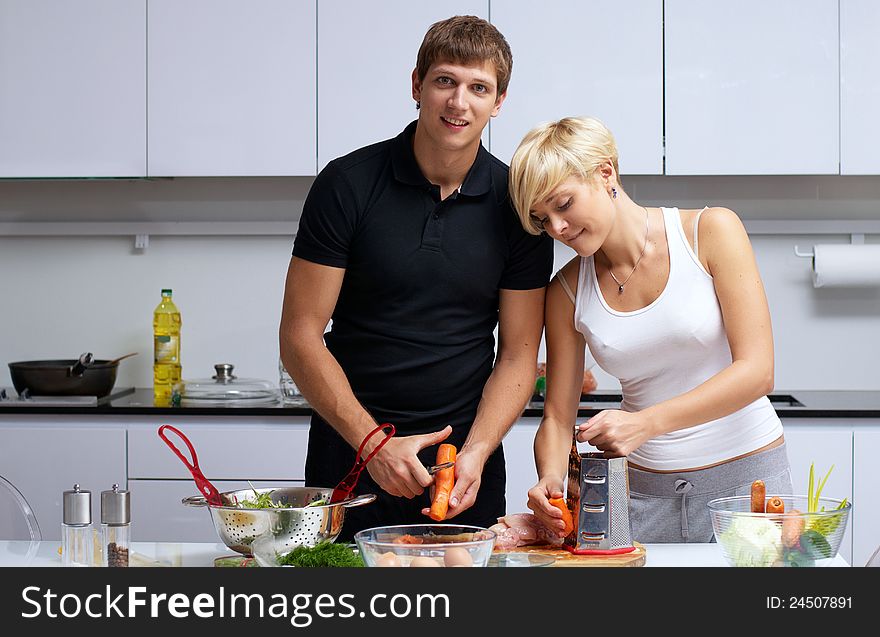 Playful young couple in their kitchen making dinner