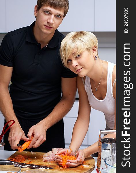 Playful young couple in their kitchen making dinner