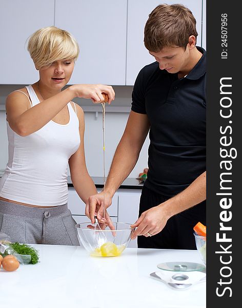 Playful young couple in their kitchen making dinner