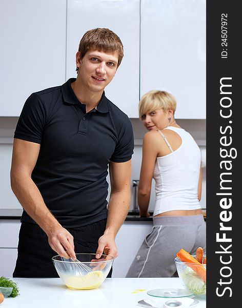 Playful young couple in their kitchen making dinner