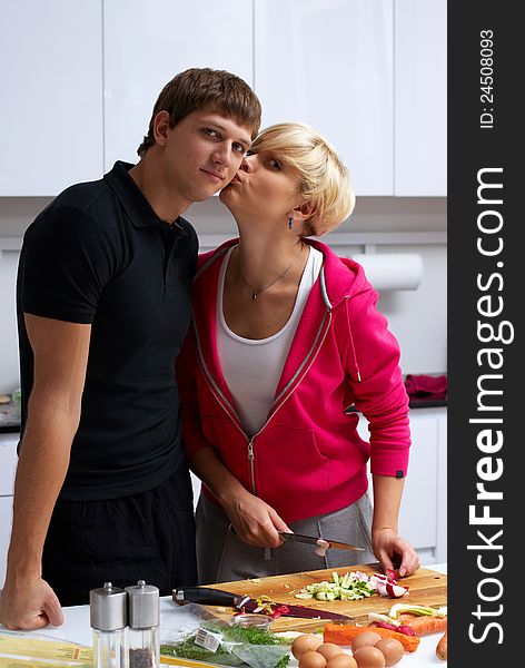 Portrait of a lovely couple making a salad in their kitchen