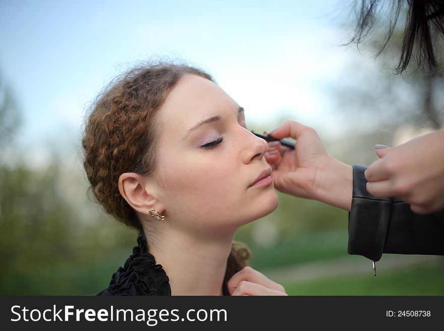 Girl doing makeup in the park spring. Girl doing makeup in the park spring