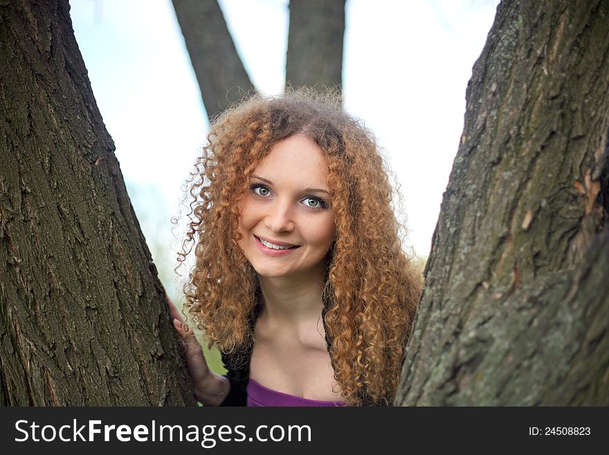 Portrait of a pretty smile girl in the trees