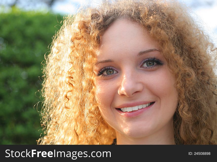 Curly-haired Girl Smiling In The Spring