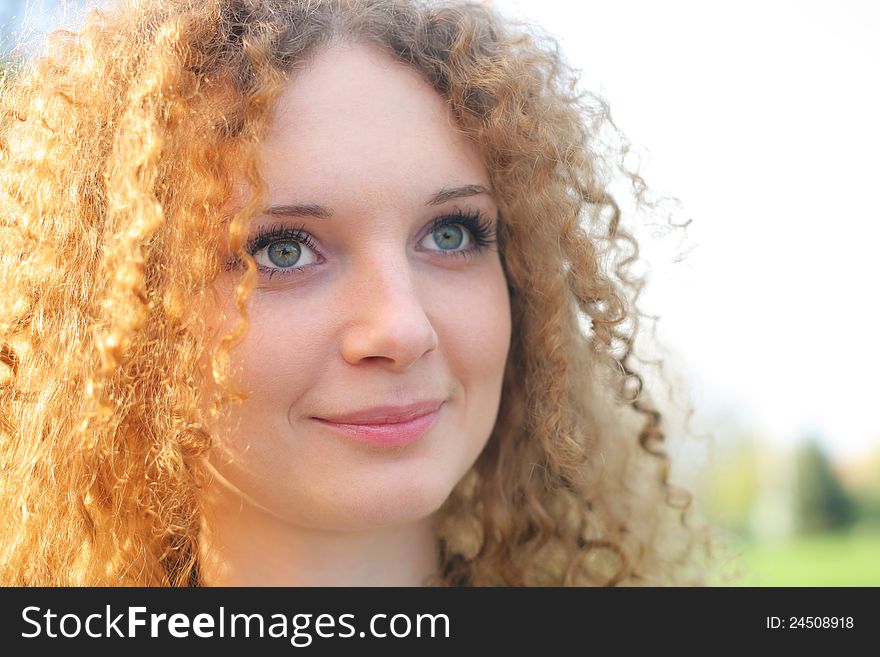 Curly-haired Girl In The Park In Spring