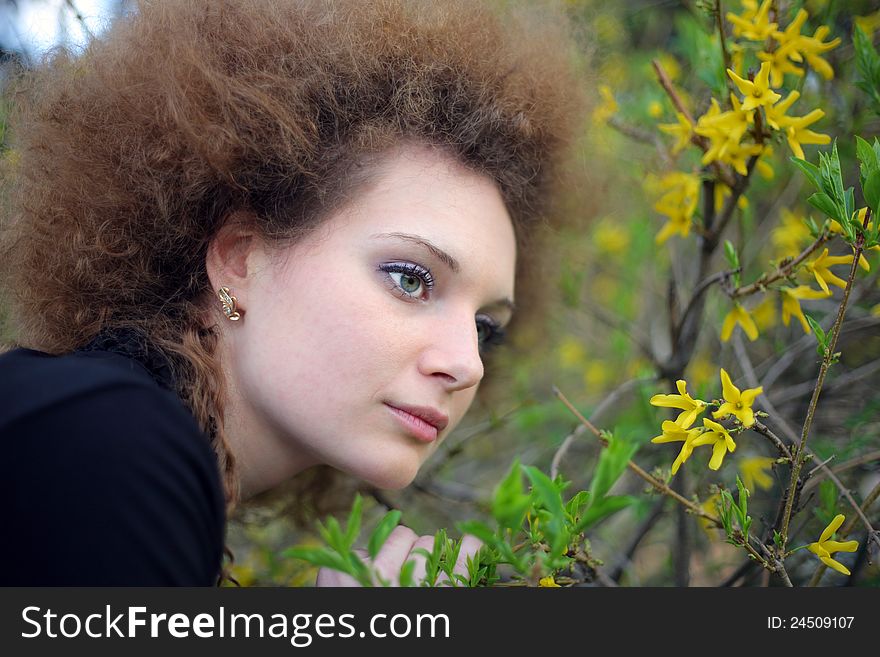 Portrait of a girl in nature with yellow flowers