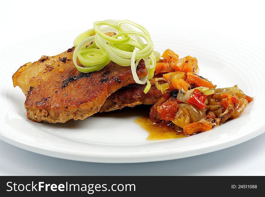 Pork steak with vegetables isolated on white background