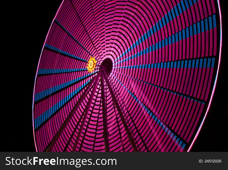 A ferris wheel at a local fair spins around to create a nice abstract image. A ferris wheel at a local fair spins around to create a nice abstract image