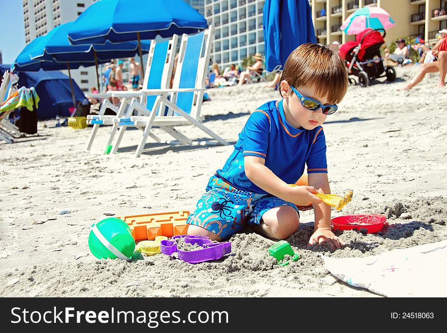 A young boy enjoys playing in sand. A young boy enjoys playing in sand