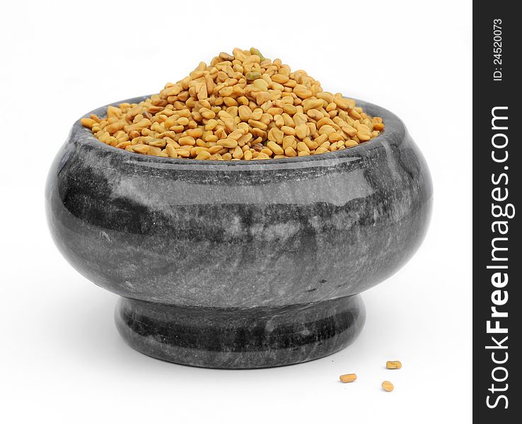 Fenugreek seeds in a mortar with gray marble