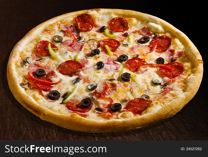 Pizza quattro stagioni with pepperoni, ham, bacon and olives - isolated