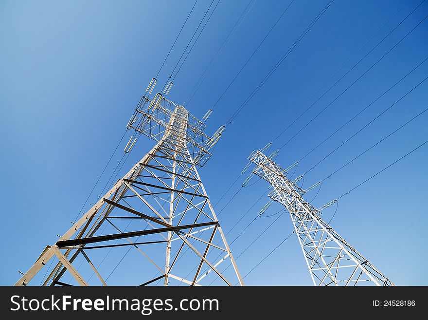 Two electrical steel pylons on blue sky. Two electrical steel pylons on blue sky