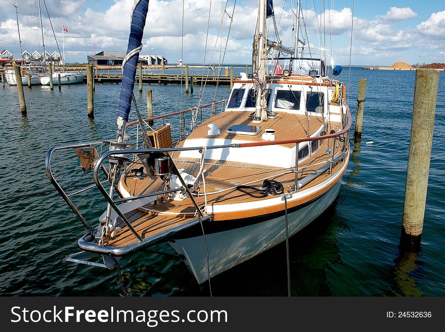 Beautiful classical design wooden sail yacht anchored in a marina. Beautiful classical design wooden sail yacht anchored in a marina