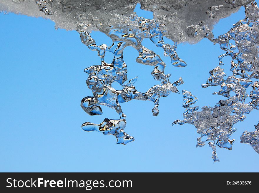 Thawing Icicles against a blue sky. Abstract form. Thawing Icicles against a blue sky. Abstract form.