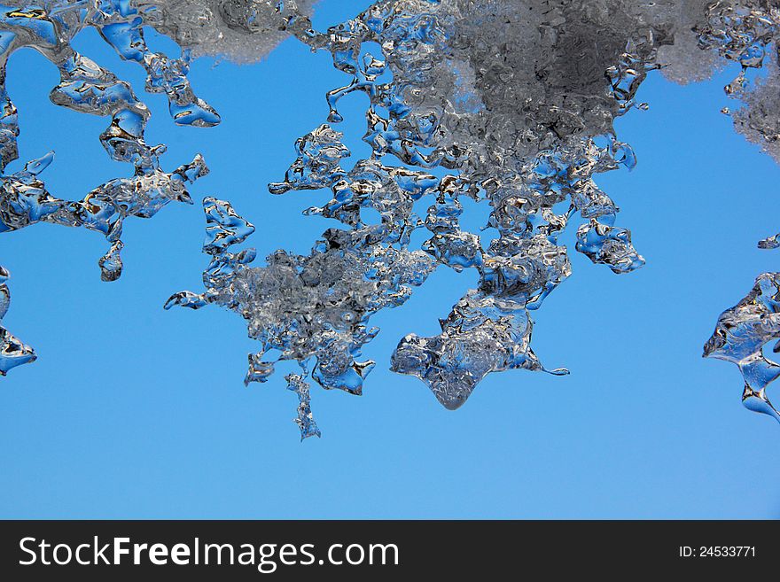 Thawing Icicles against a blue sky. Abstract form. Thawing Icicles against a blue sky. Abstract form.