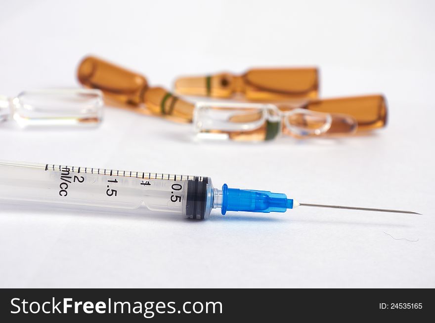 Disposable syringe and ampoules on white background