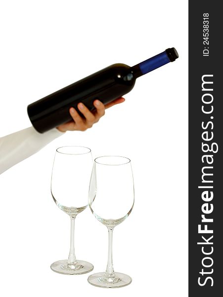 A hand offering bottle of red wine with two empty glasses isolated on a white background. A hand offering bottle of red wine with two empty glasses isolated on a white background