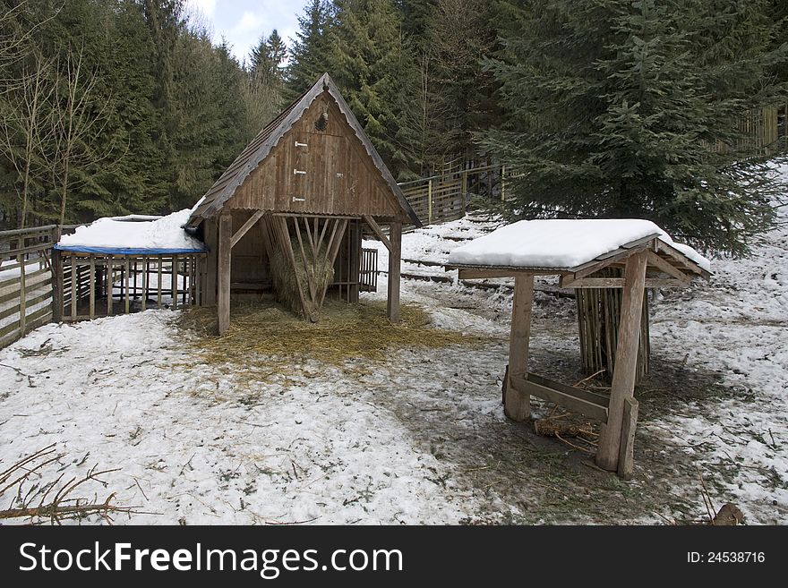 Wooden shelter for wild animals in winter, wooden fence around the enclosure for wild animals. Wooden shelter for wild animals in winter, wooden fence around the enclosure for wild animals