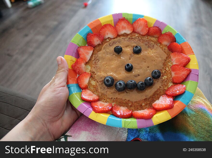 A Smiling Face Made Of Pancakes With Strawberries And Blueberries