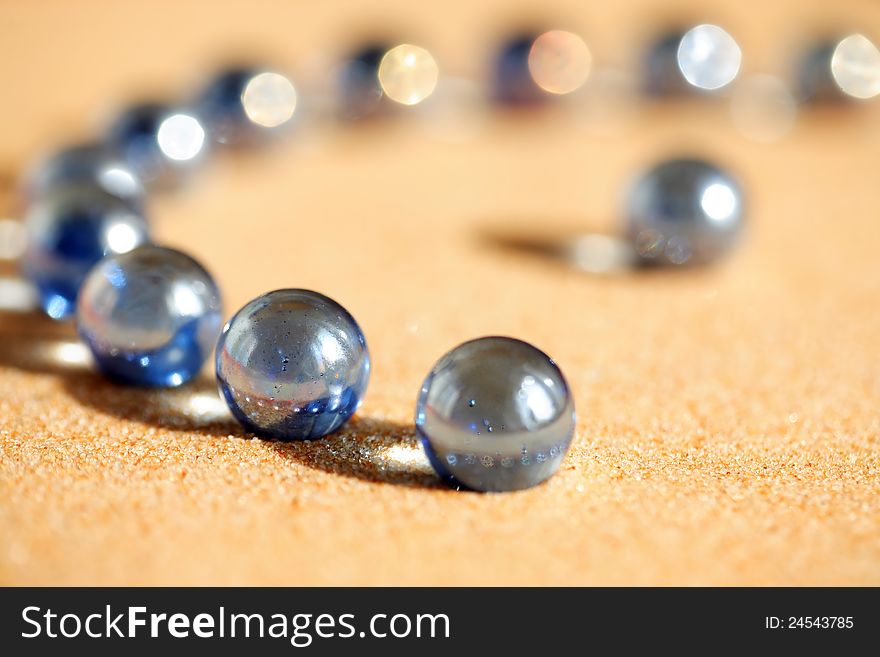 Abstract composition with few blue glass balls on sand surface. Abstract composition with few blue glass balls on sand surface