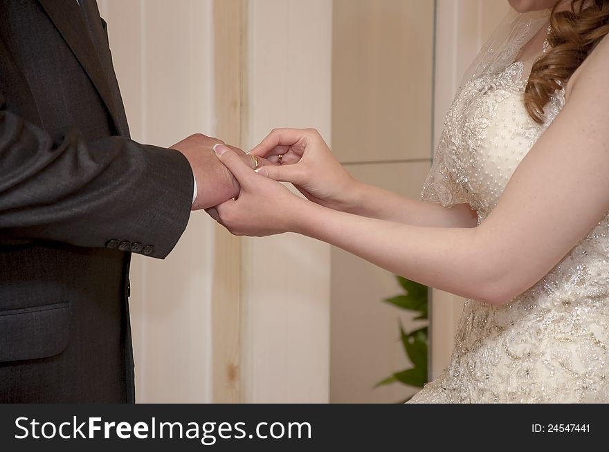 The bride puts on a wedding ring to the groom. The bride puts on a wedding ring to the groom