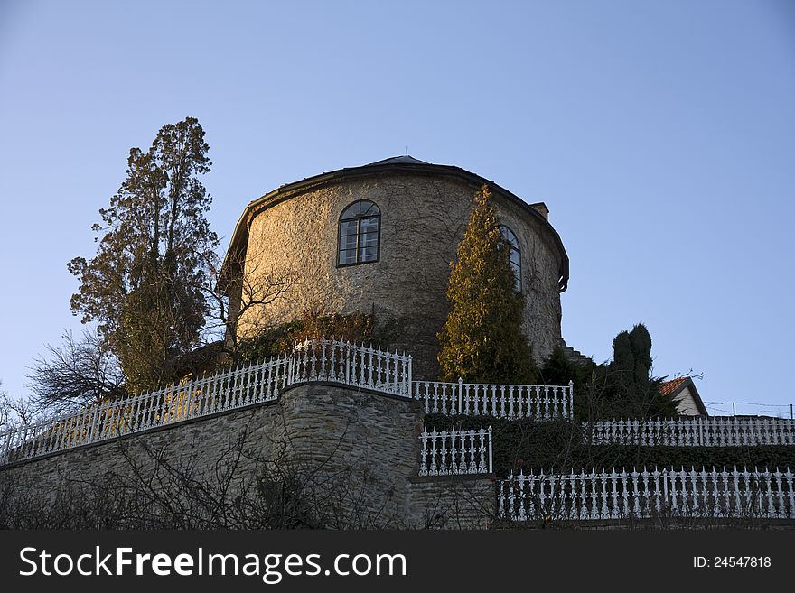 Small house on a hill with a fenced garden. Small house on a hill with a fenced garden