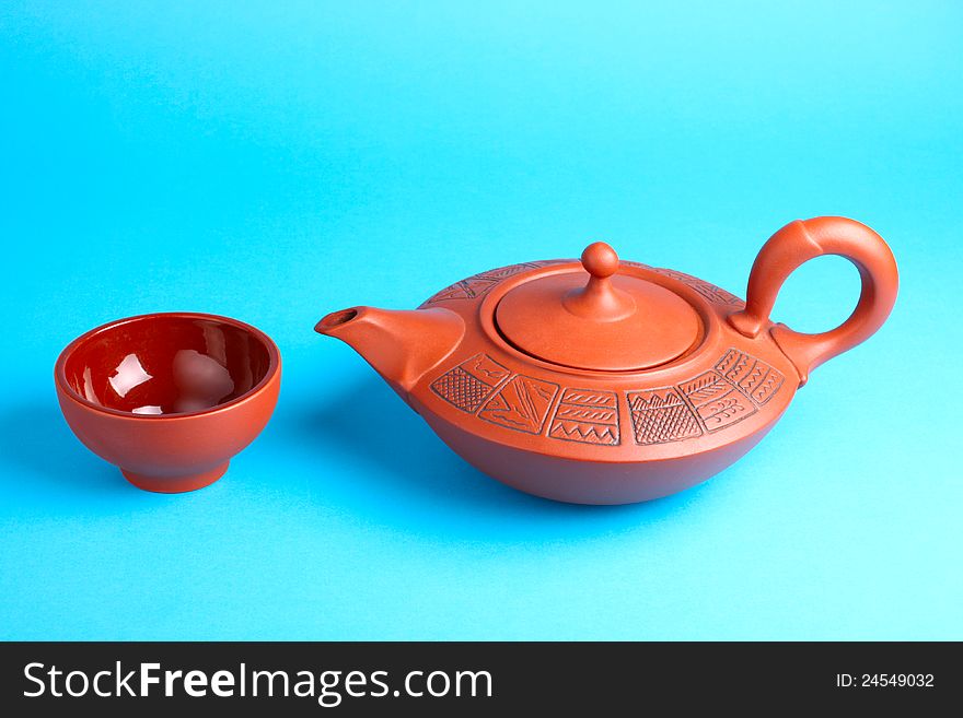 Arabian old ceramic brown teapot with teacups isolated on blue. Arabian old ceramic brown teapot with teacups isolated on blue