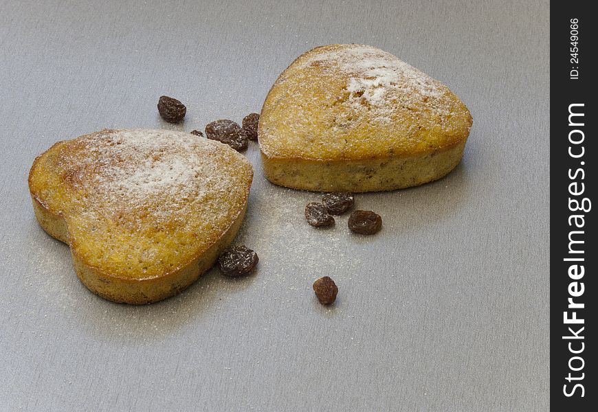 Two heart-shaped cake of raisins sprinkled with powdered sugar