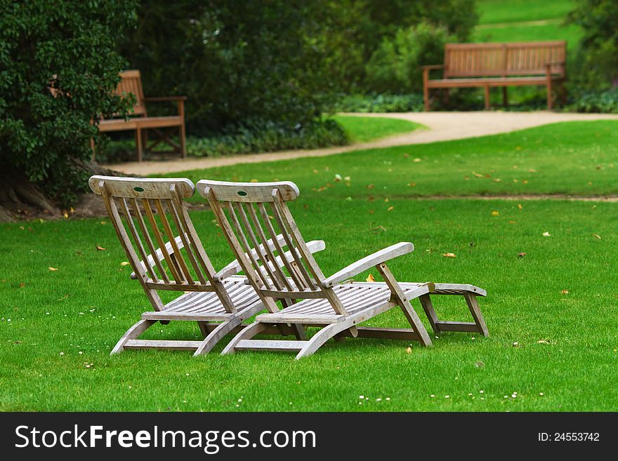 Two deckchairs side by side standing on the lawn of a park. Two deckchairs side by side standing on the lawn of a park