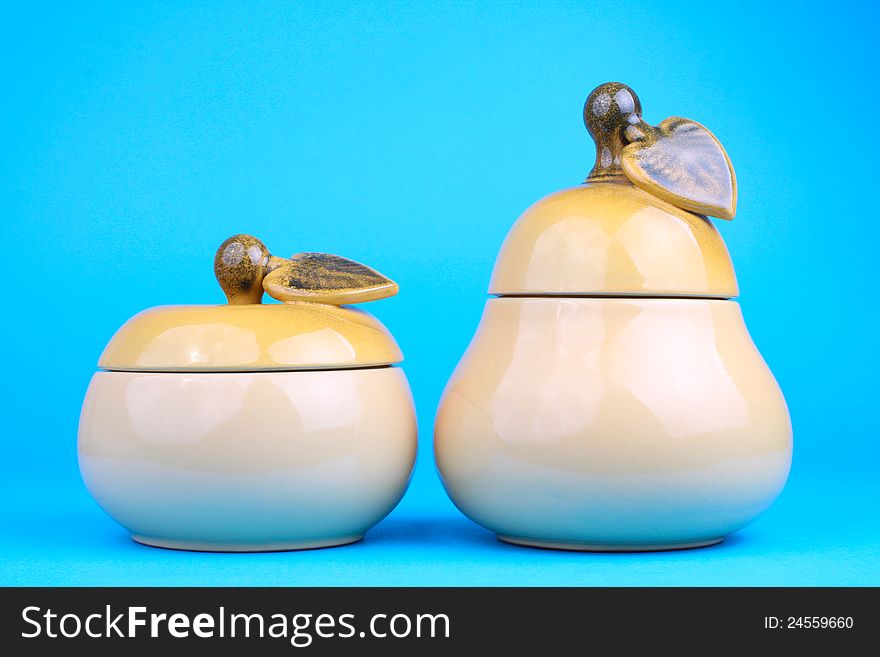 Two sugar-bowls in the form of a pear and apple  on blue background