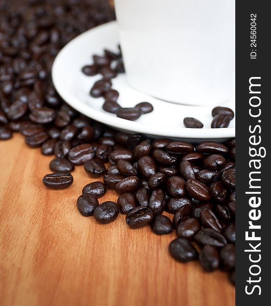 Coffee beans with white coffee cup on wood texture. Coffee beans with white coffee cup on wood texture.