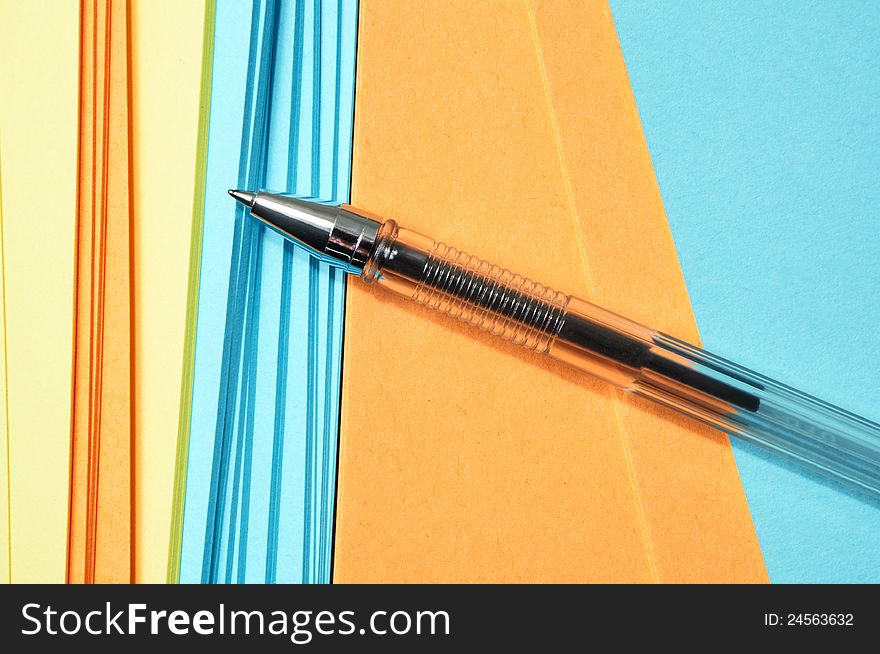 Pen and multi-colored note paper. Pen and multi-colored note paper