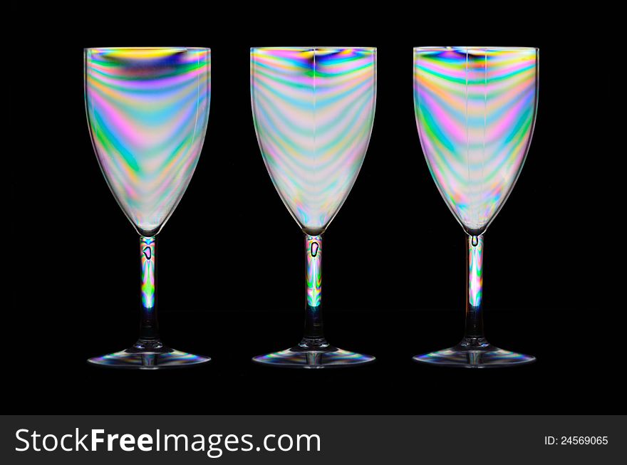 Three plastic picnic wine glasses reflecting the spectrum using polarization. Three plastic picnic wine glasses reflecting the spectrum using polarization.
