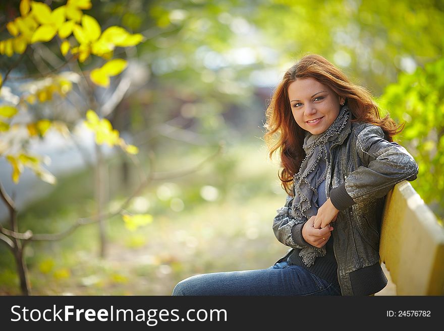 Girl sitting on a bench in autumn. Girl sitting on a bench in autumn