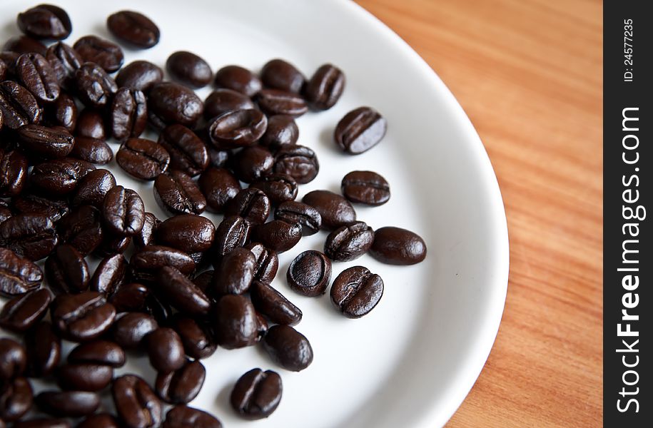 Coffee beans in a disk on  wooden board. Coffee beans in a disk on  wooden board.