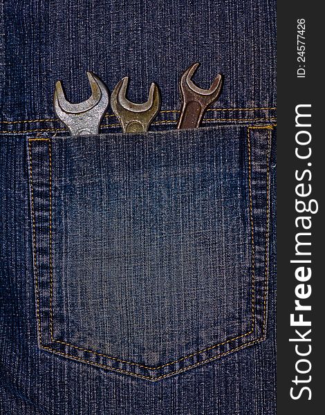 This is three wrenches in pocket of fabric jeans. It is theme of tools.