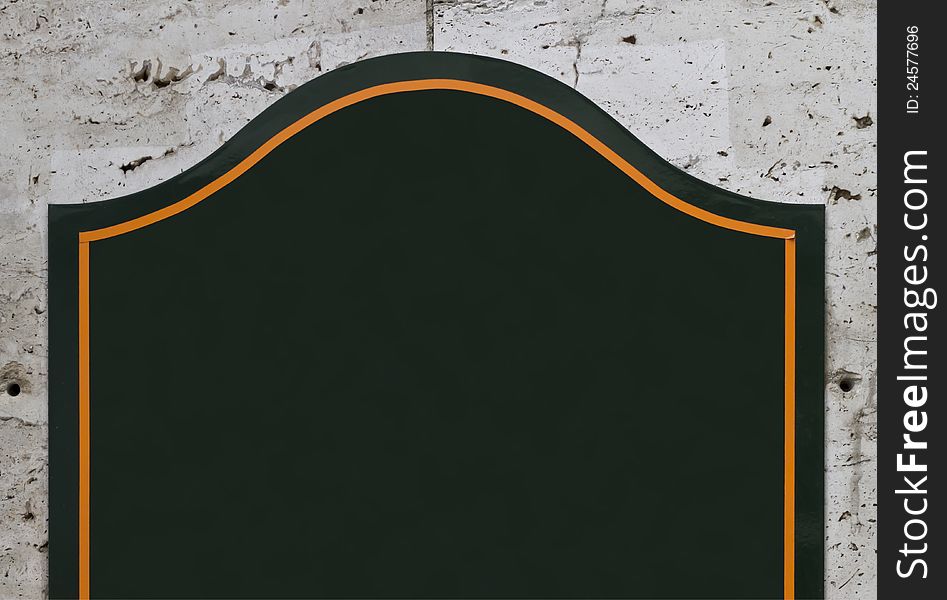 Part of dark green blank sign on concrete wall