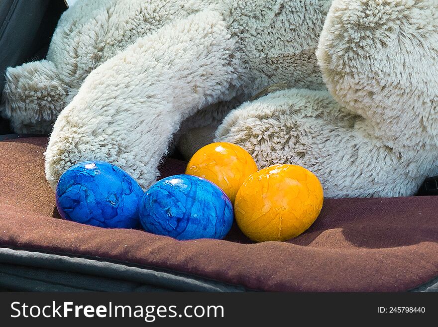 Blue and yellow eggs near the toy rabbit