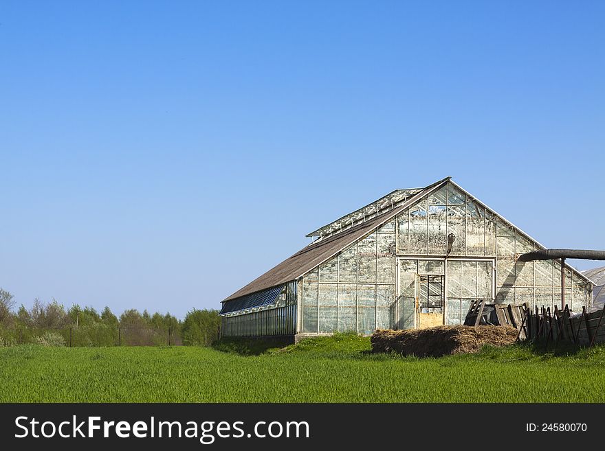 Fields with greenhouse and blue sky.