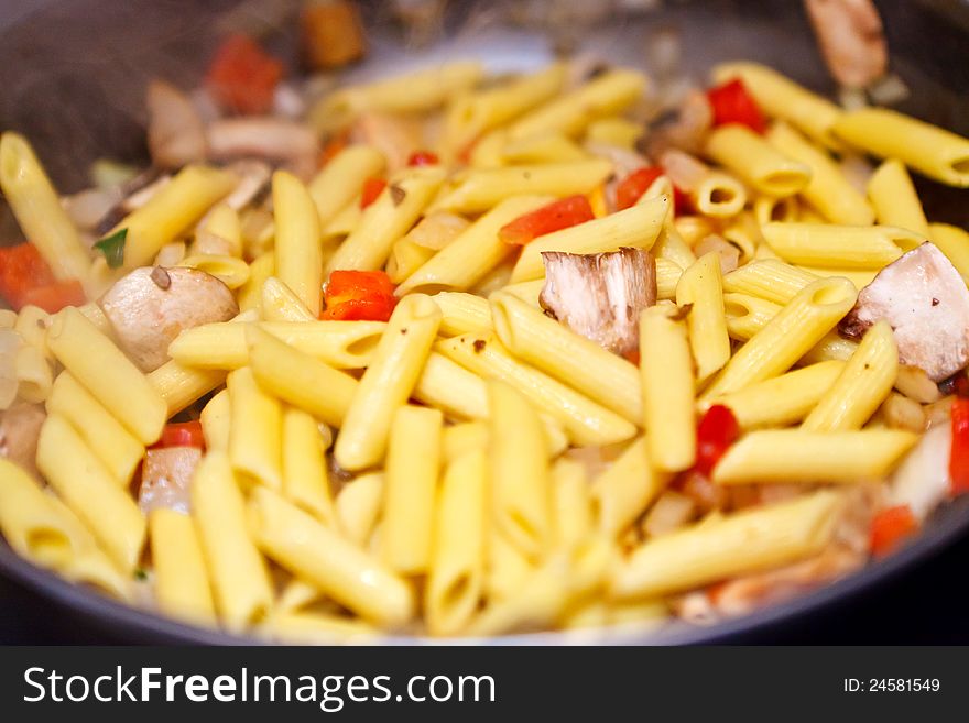 Pasta is being cooked in a pan. Pasta is being cooked in a pan