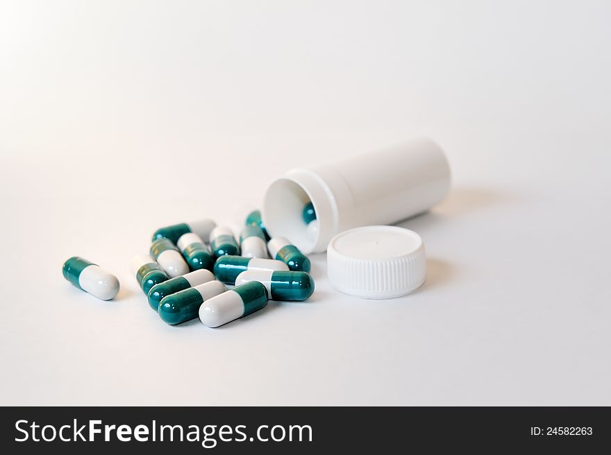 Scattered tablets from the container on a white background. Scattered tablets from the container on a white background