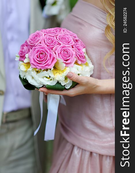 A bouquet of pink roses in the hands of a woman