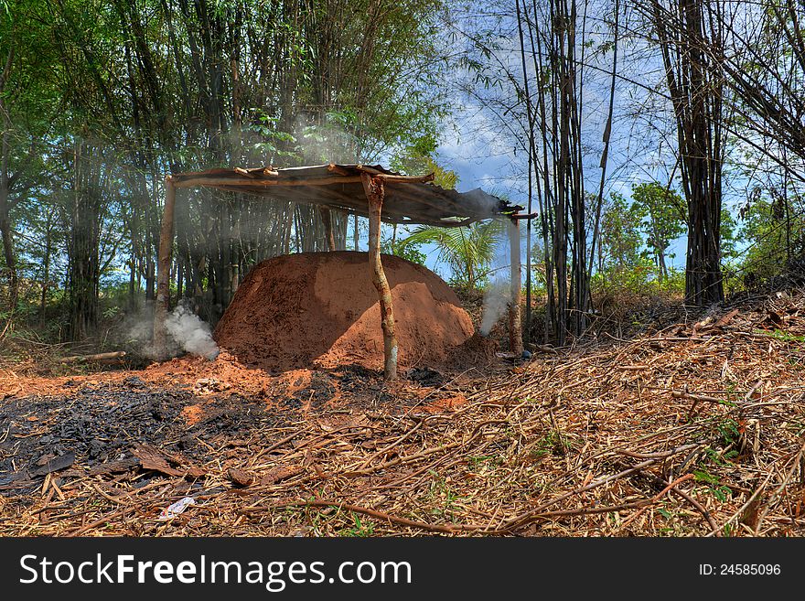 A homemade oven that produces coal from wood. picture taken in a forest in thailand. A homemade oven that produces coal from wood. picture taken in a forest in thailand.