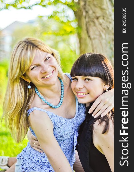 Two beautiful happy sisters in the park. Two beautiful happy sisters in the park