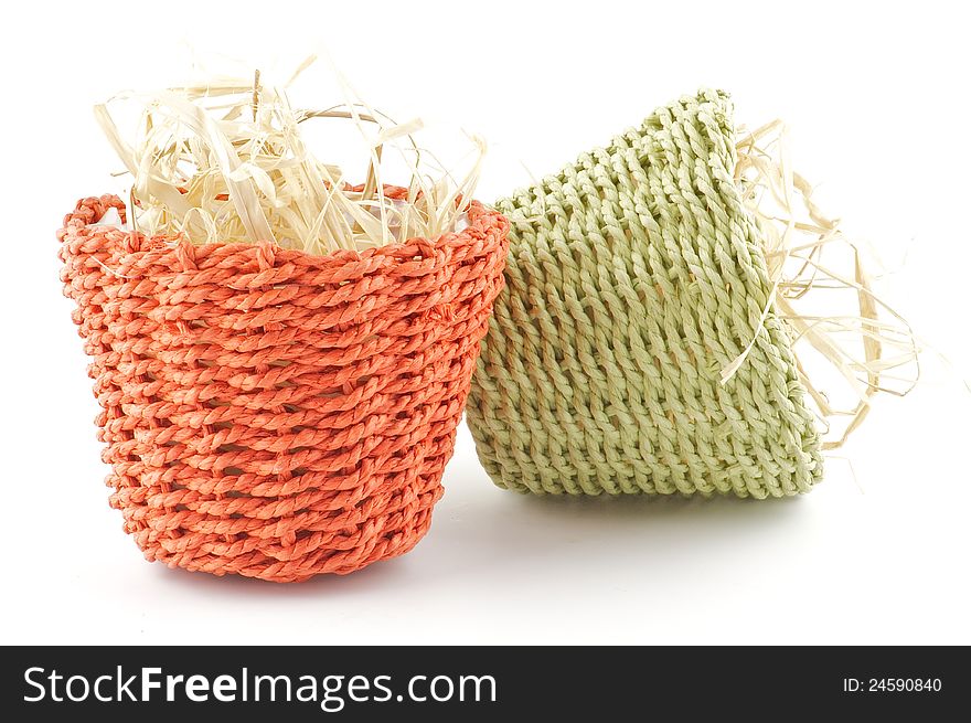 Green and red little wicker flower pots with straw isolated on white background. Green and red little wicker flower pots with straw isolated on white background