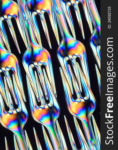 Small eating forks consisting of transparent plastic seen in polarized light. Small eating forks consisting of transparent plastic seen in polarized light