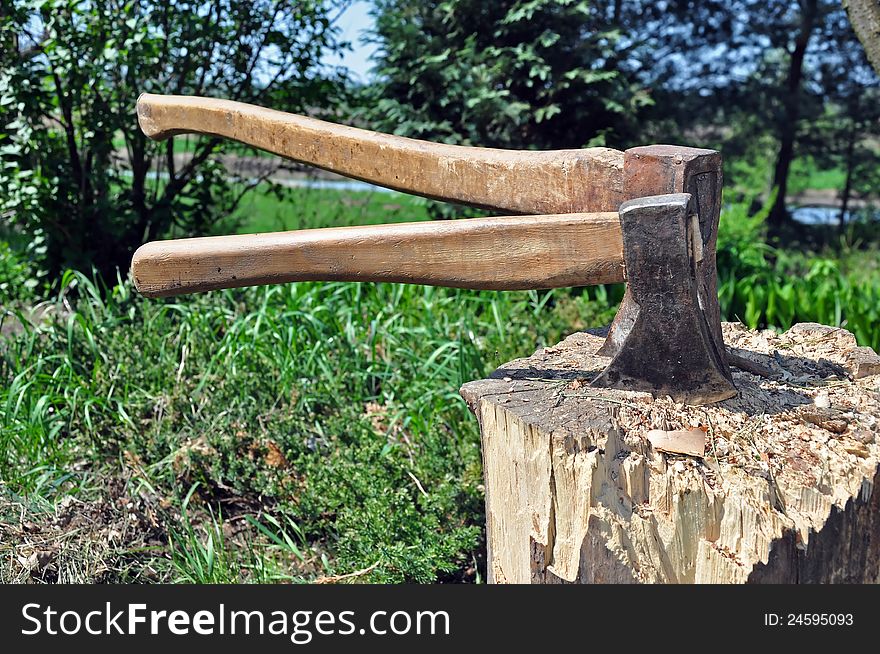 Two axes stuck in a wooden chopping block. Two axes stuck in a wooden chopping block