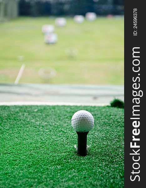 Golf ball on tee with green grass. Golf ball on tee with green grass